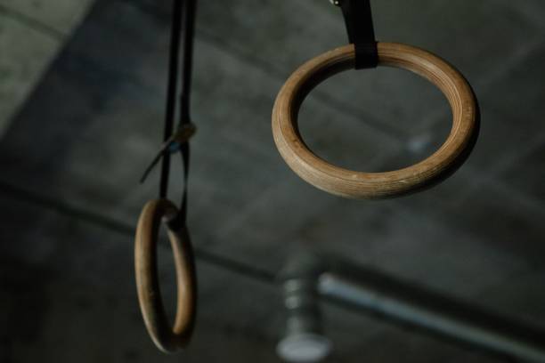 istock Artistic Gymnastics Still Rings Hanging in Gym against Concrete Ceiling 2178153699