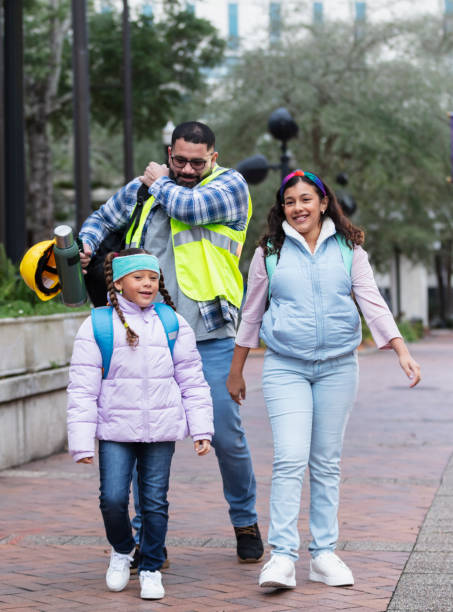istock Hispanic father taking daughters to school in city 2178155873
