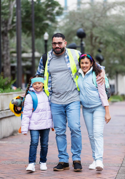istock Hispanic father taking daughters to school in city 2178155877
