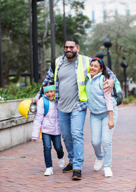 istock Hispanic father taking daughters to school in city 2178155880