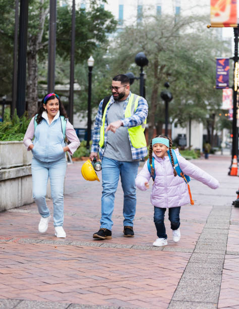 istock Hispanic father taking daughters to school in city 2178155881