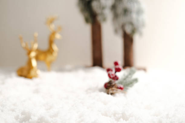 Blurred Winter scene with snow, berries, deer, and trees. Perfect for holiday designs, greeting cards, festive backgrounds, and seasonal decorations.