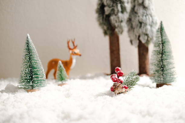 istock Snow, red berries, pine trees, reindeer, miniature winter scene. 2178159642
