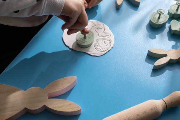 istock Workshop cutting figures Unrecognizable artist do it yourself air dry clay crafts for Easter holiday. Decoration gift idea Handmade children craft. Step by step instruction of painting, pressing figures 2178159655