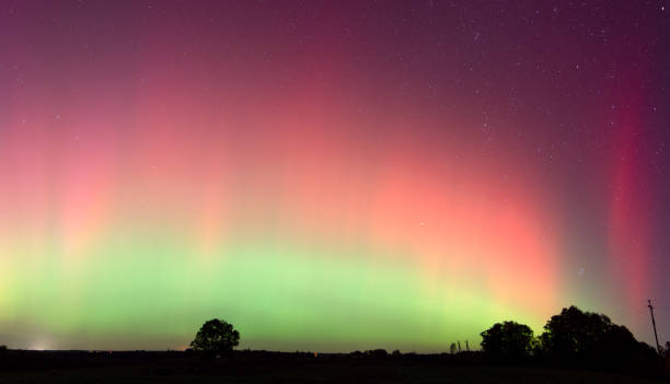 istock Pink, yellow and red aurora dancing over the Lithuania. A great solar storm. Night sky under a geomagnetic storm turning pink. Northern lights. 10 11 2024 2178167298