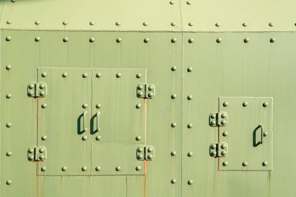 Details of the fuselage of an old aircraft. Old camouflage surface with exfoliated paint and rivets on a military aircraft.