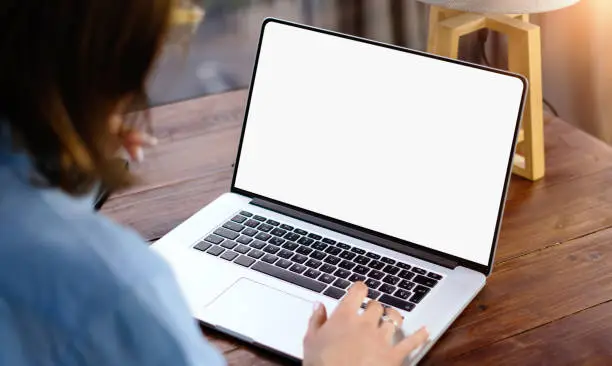 Mockup image of a woman using laptop with blank screen on wooden table Mockup image of a woman using laptop with blank screen on wooden table
