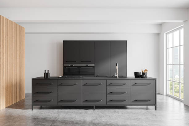 istock A modern kitchen featuring sleek dark cabinetry with minimalistic design elements. Set against a white background with large windows, showcasing a contemporary home interior. 3D Rendering 2178169079
