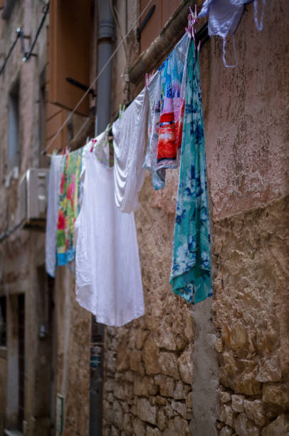 Woman hangs her laundry on the balcony on a sunny day