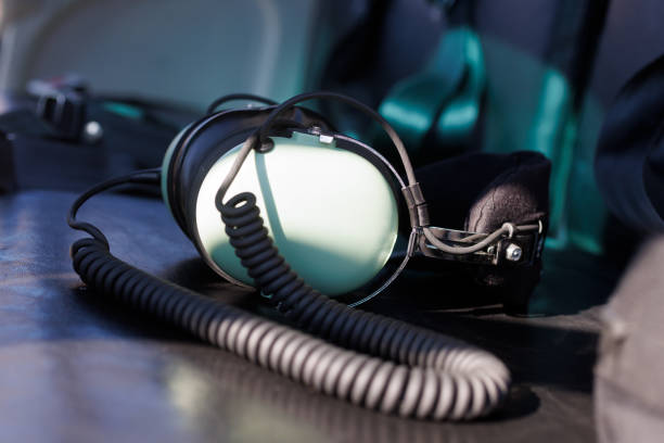 Aviator headphones resting on a black leather seat inside a helicopter cockpit. The image evoking a sense of aviation, adventure, and freedom in the skies. Perfect for themes of air travel and exploration.