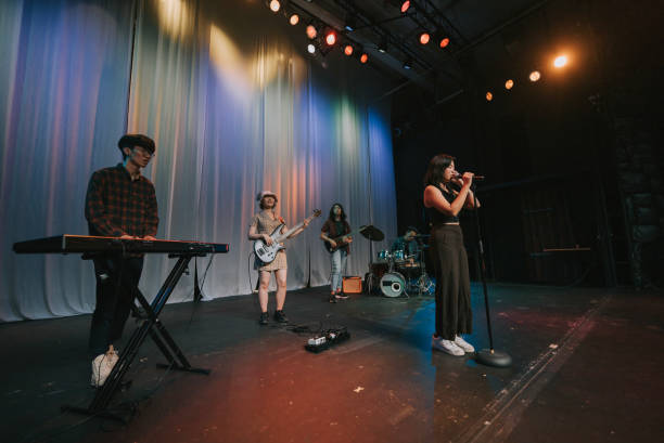 istock Young Asian chinese lead singer and live band Multiracial group performance on stage 2178174757