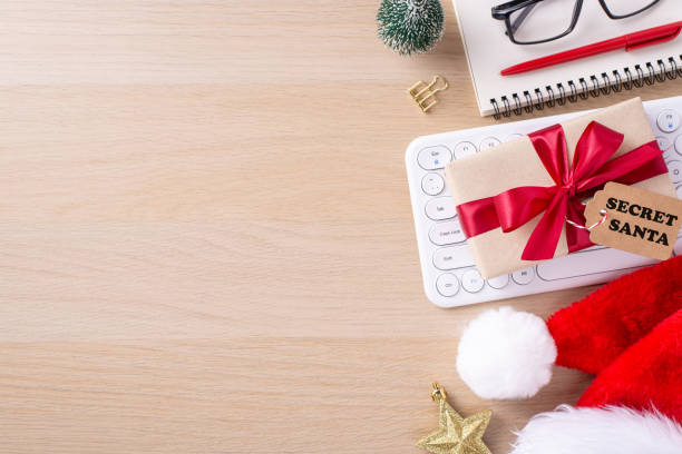 istock Top view of a festive office workspace featuring a keyboard, wrapped gift with red ribbon, Santa hat, and small decorations evoking the Christmas spirit 2178175904