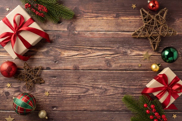 istock Festive Christmas scene with gift boxes, decorative ornaments, and pine branches on a rustic wooden surface to evoke holiday warmth and joy 2178175911
