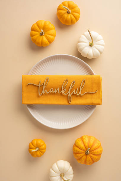 istock Elegant vertical Thanksgiving table setting featuring a thankful decoration on a plate surrounded by mini pumpkins, creating a warm and festive atmosphere 2178175936