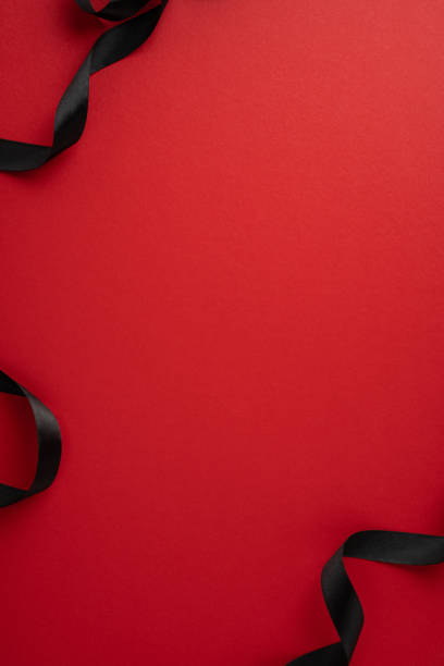 istock A striking red vertical background is adorned with elegantly flowing black ribbons, perfect for Black Friday sales promotions or festive gift themes 2178175947