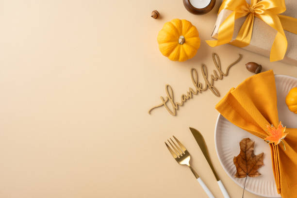 istock Flat lay of a Thanksgiving table setting featuring a pumpkin, gift box with ribbon, and autumn leaves creating a festive atmosphere 2178175967