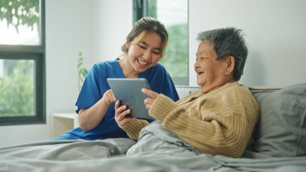 istock Home caregiver using technology health with her elderly patient. 2178177063