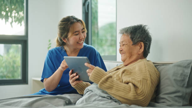 istock Home caregiver using technology health with her elderly patient. 2178177064