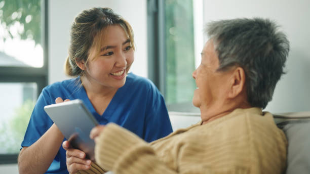 istock Home caregiver using technology health with her elderly patient. 2178177067