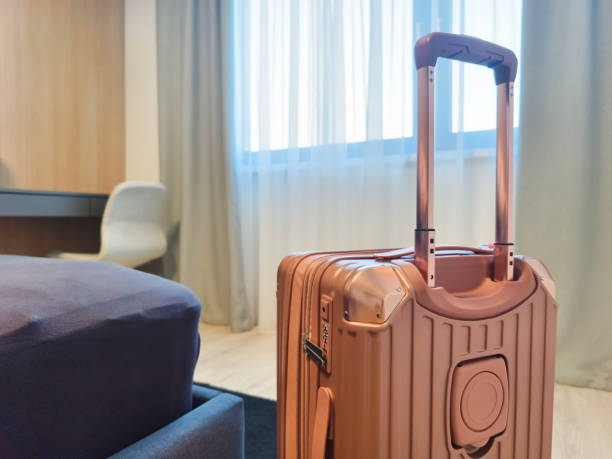 istock A pink suitcase is on the floor in a hotel room. 2178179070
