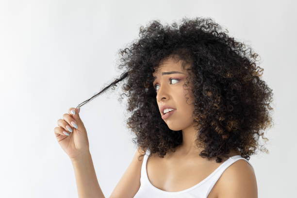 istock Curly haired woman looking at her hair 2178179404