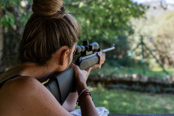 istock A woman is holding a gun and looking through the scope 2178187041
