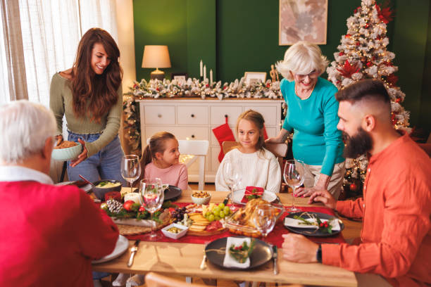 istock Women setting the table while having family Christmas dinner at home 2178189748
