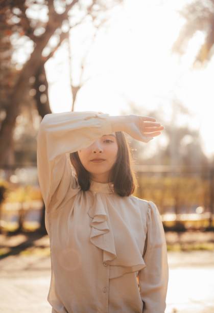 istock Young Hispanic woman with eyes closed enjoying sunlight in a park 2178191030