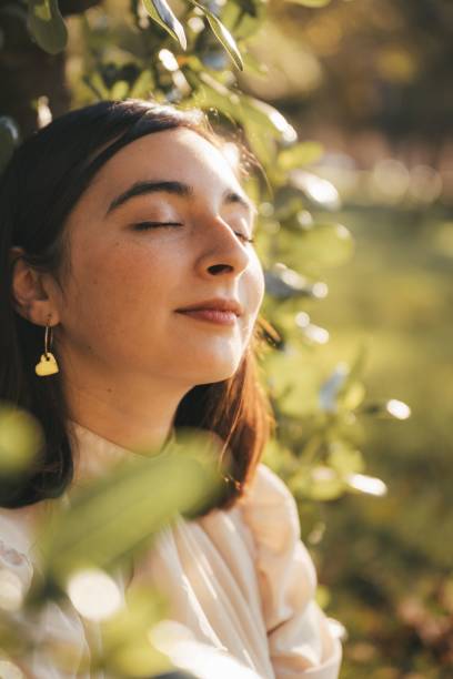 istock Young Hispanic woman with eyes closed enjoying sunlight in a park 2178191047