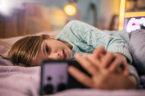 istock Teenage child lying on couch  watching something on phone. 2178193648
