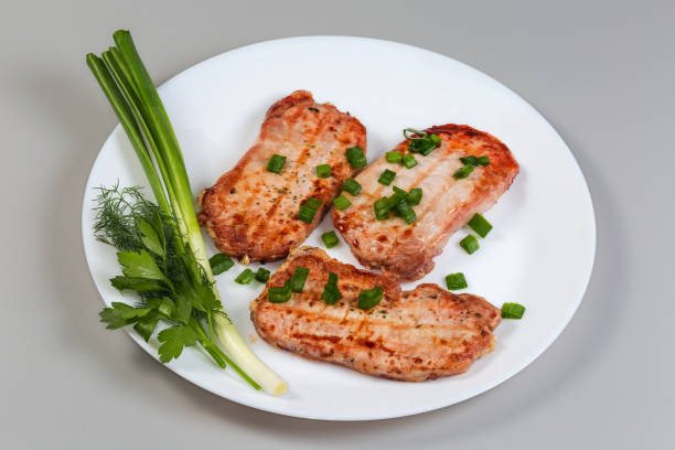 Juicy fried chicken fillet with rice on a plate. Delicious breakfast with meat and rice.