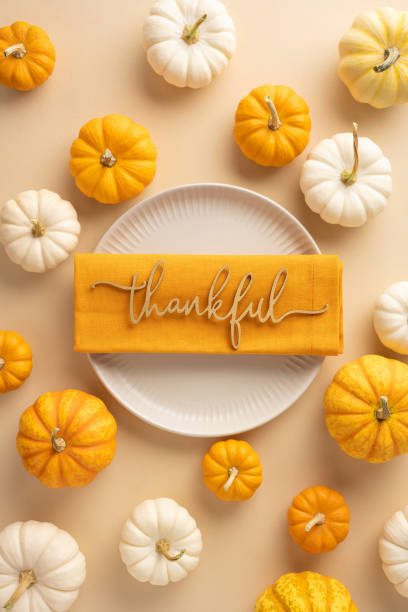 istock Festive vertical Thanksgiving table setting featuring small pumpkins surrounding a plate with a thankful message, creating a warm and inviting holiday atmosphere 2178202443