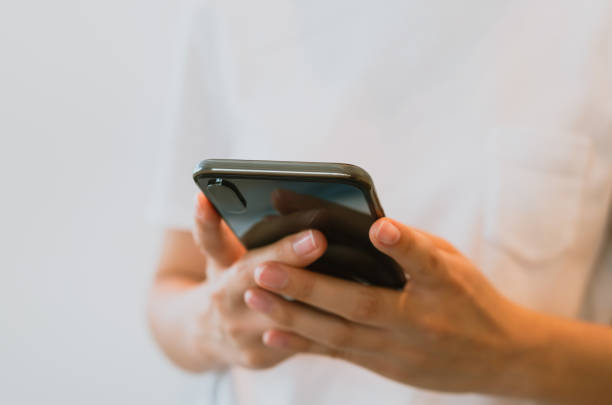 istock Woman's hands holding smartphone and using a social media at night street. 2178207771