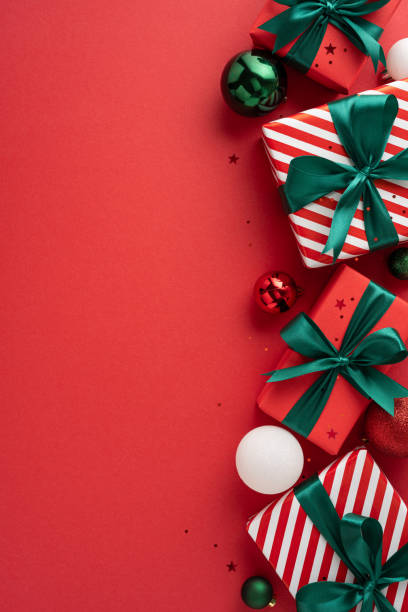 istock Festive Christmas vertical image featuring beautifully wrapped gifts and colorful decorations on a vibrant red background, perfect for holiday celebrations and seasonal joy 2178209061