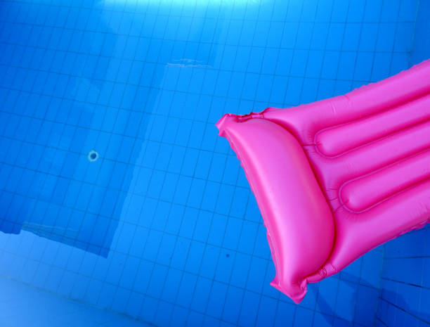 Pink inflatable mattress on blue pool