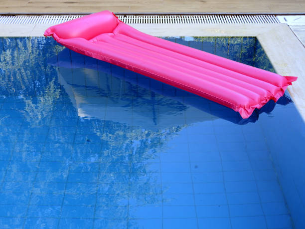 istock Pink inflatable mattress on blue pool 2178209928