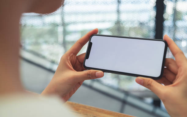 istock Hand holding black smartphone with blank screen for graphic display montage at shopping mall background. 2178211772
