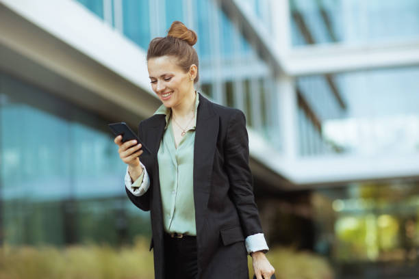 istock happy woman worker near office building using phone and walking 2178212617