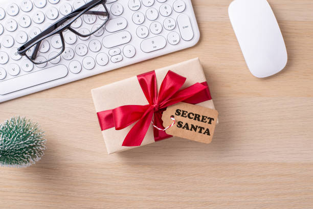 istock A gift with a red ribbon on a desk, next to a keyboard, mouse, and glasses, symbolizing office holiday celebrations 2178214438