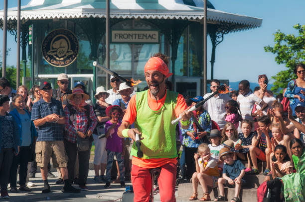 Quebec City, Canada. July 7, 2019.  A street performer juggling fire sticks on a unicycle in old quebec city canada.