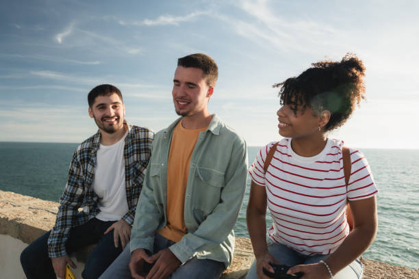 istock Three friends enjoying conversation by the sea 2178216739