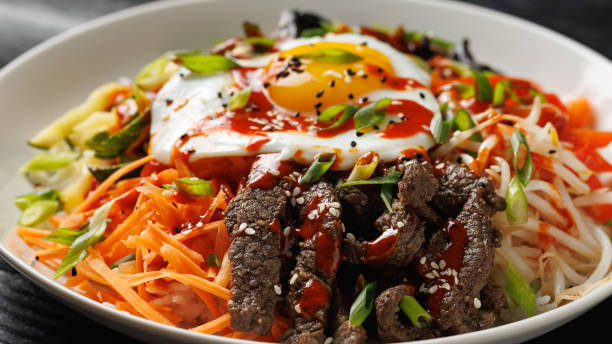 istock Traditional Korean dish Bibimbap with rice, vegetables beef and egg in a white plate 2178216880