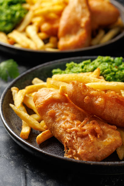 istock British Fish and chips with mashed peas, tartar and ketchup sauce. 2178216927