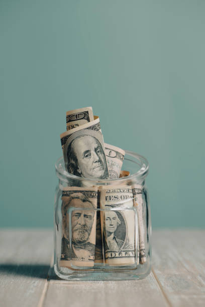 istock Saving Money in a Glass Jar Filled with Dollar Bills 2178217385