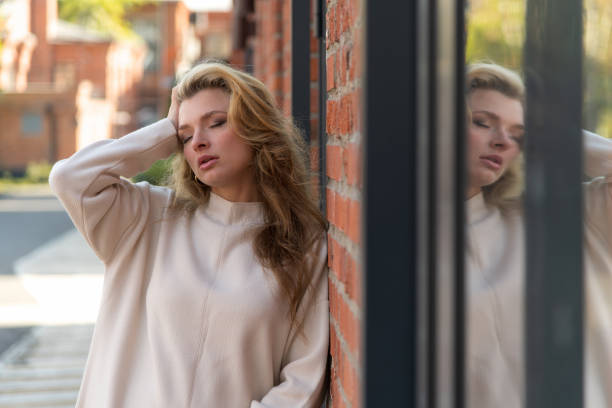 istock Woman with eyes closed by window 2178222067