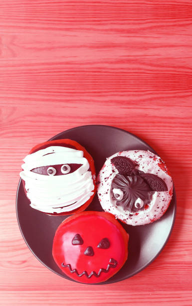 istock Assorted Halloween Doughnuts on Red Wooden Background 2178229268