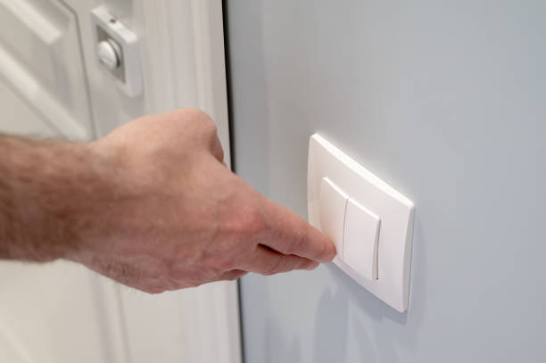 istock The man turns off the light to save electricity. Modern white light switch 2178229425