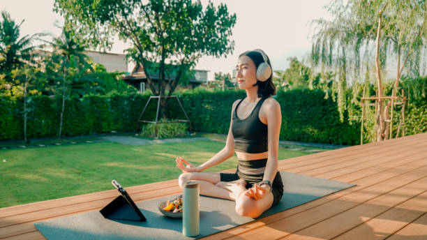 istock Young Asian woman folding her hands while doing yoga peacefully at home. 2178229938