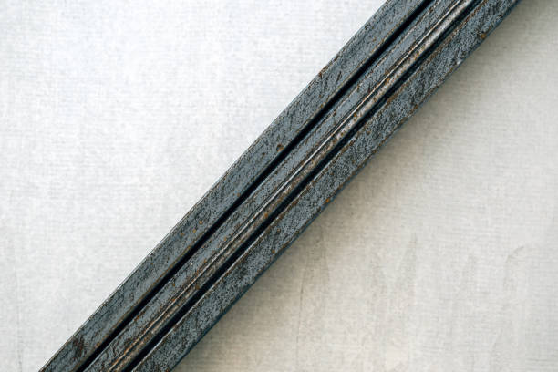 Stack of square steel tubes leaning against the wall with copy space