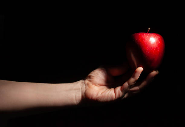 istock red delicious apple in hand on black 2178235020